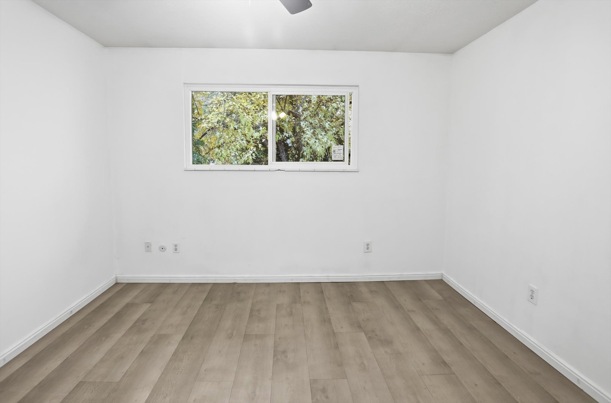 Room featuring wood-finish flooring and white baseboards