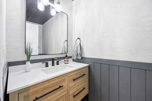 Modern vanity with a white countertop and integrated sink, featuring a matte black faucet