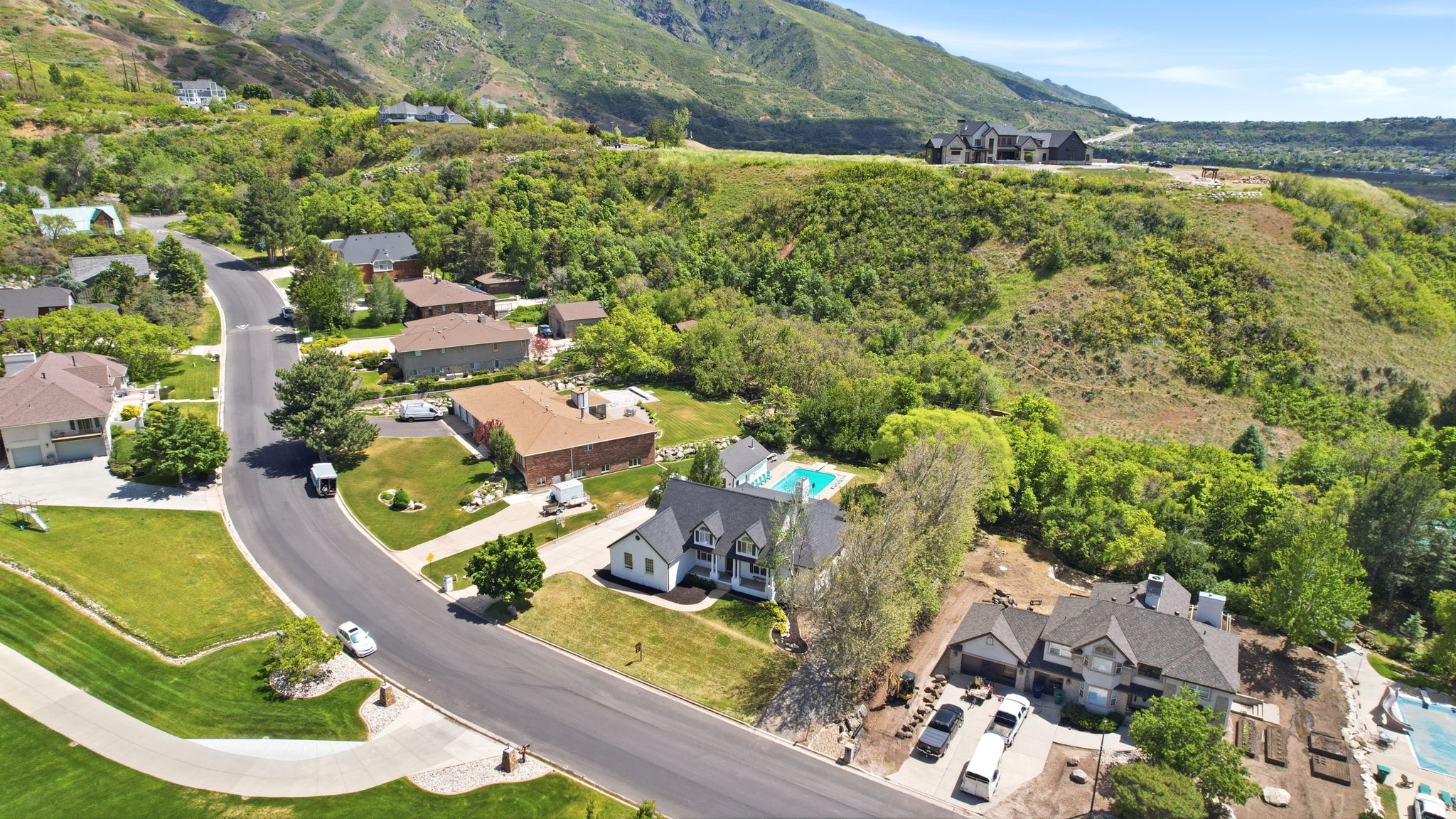 Aerial perspective showcasing a residential neighborhood nestled on a hillside with abundant green landscaping