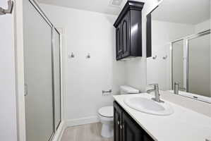 Bathroom featuring a white vanity countertop, undermount sink, and black wood-finish cabinetry