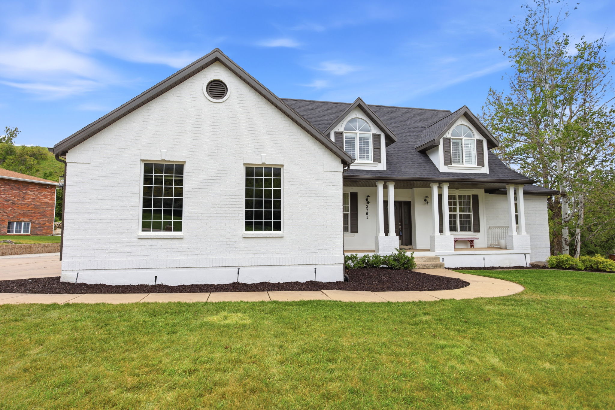 White brick exterior with dark gray roofing