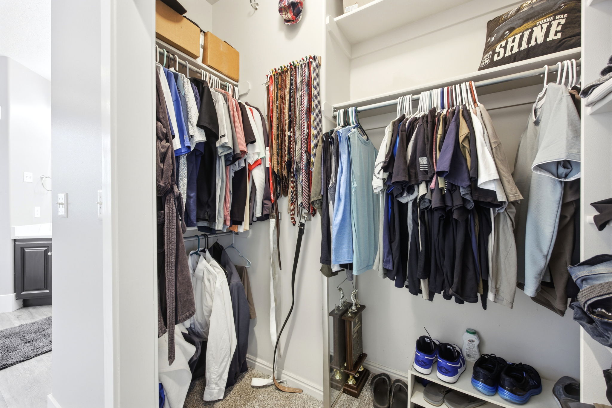 Custom closet system with multiple hanging rods, integrated shelving, and dedicated shoe storage