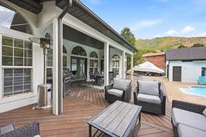 Expansive wood-finish deck featuring a covered patio, multiple arch-top windows, and french doors