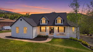 White brick exterior featuring a dark asphalt shingle roof and prominent dormer windows
