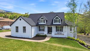 White brick residence with a dark shingle roof and a covered porch
