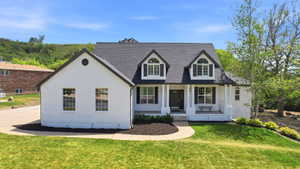 White brick exterior with a dark shingle roof and black shutters