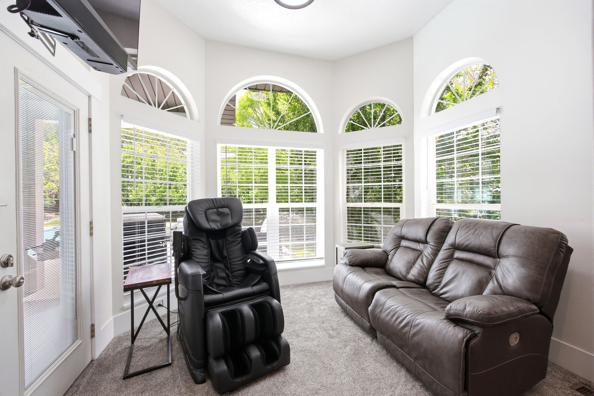 Bright interior space featuring multiple arched transom windows and white window blinds