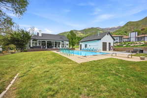Expansive outdoor area featuring a swimming pool, adjacent pool house, and a spacious lawn