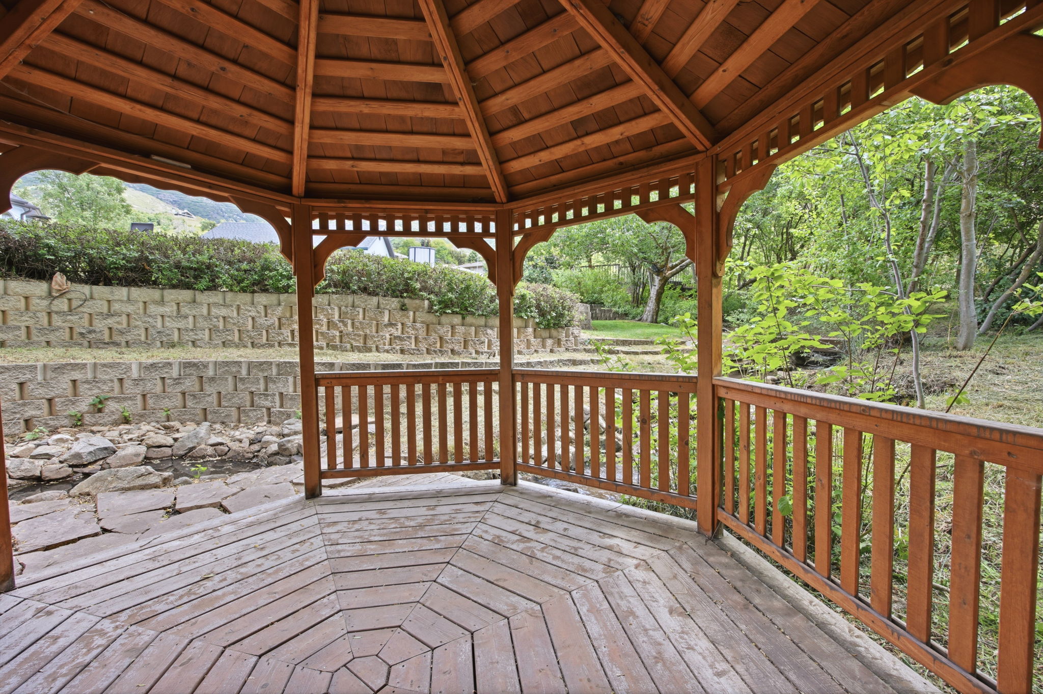 Wood gazebo featuring a multi-sided design and a slatted wood ceiling