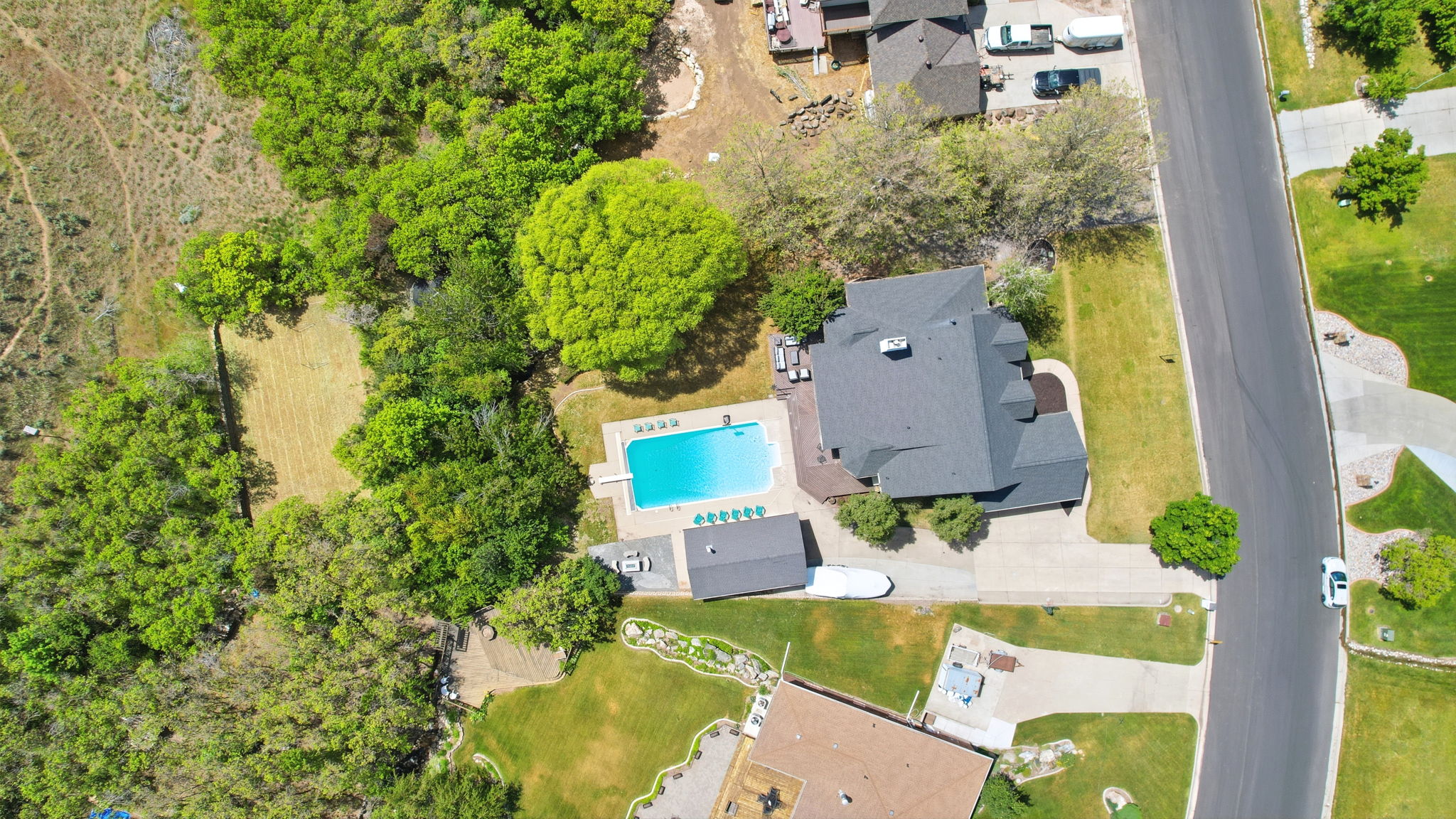 Aerial property view featuring a residential structure with a dark roof