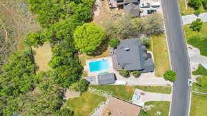 Aerial property view featuring a residential structure with a dark roof