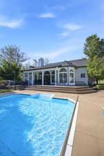Private outdoor pool with integrated steps, surrounded by a concrete deck