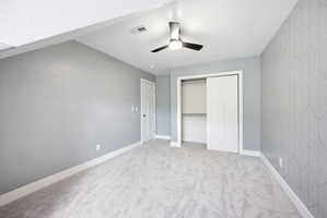 Room featuring light gray walls, gray carpeting, and a decorative accent wall