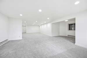 Expansive interior space featuring light gray carpeting and white walls