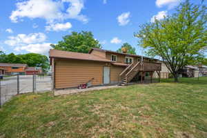 Expansive backyard with a wooden deck and a mature tree