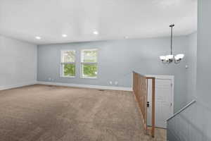 Upper-level living area with neutral carpeting and a shiplap accent wall
