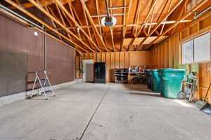 Spacious garage, a large window providing ambient light, entrance to backyard and basement