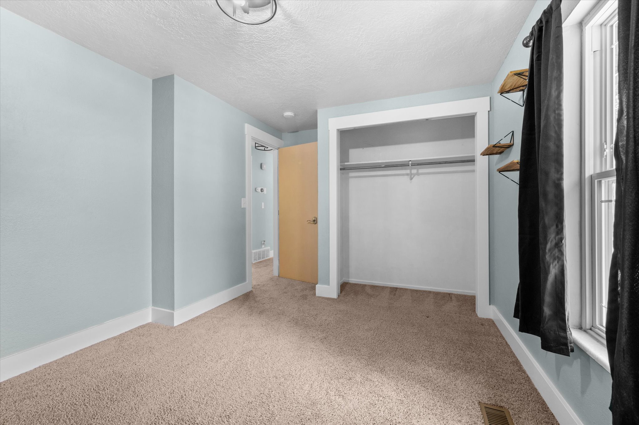 Bedroom #2 featuring light blue walls, a neutral-toned carpet, and white trim