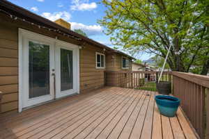 Walk out from Kitchen to a spacious outdoor deck featuring wood flooring and a perimeter railing