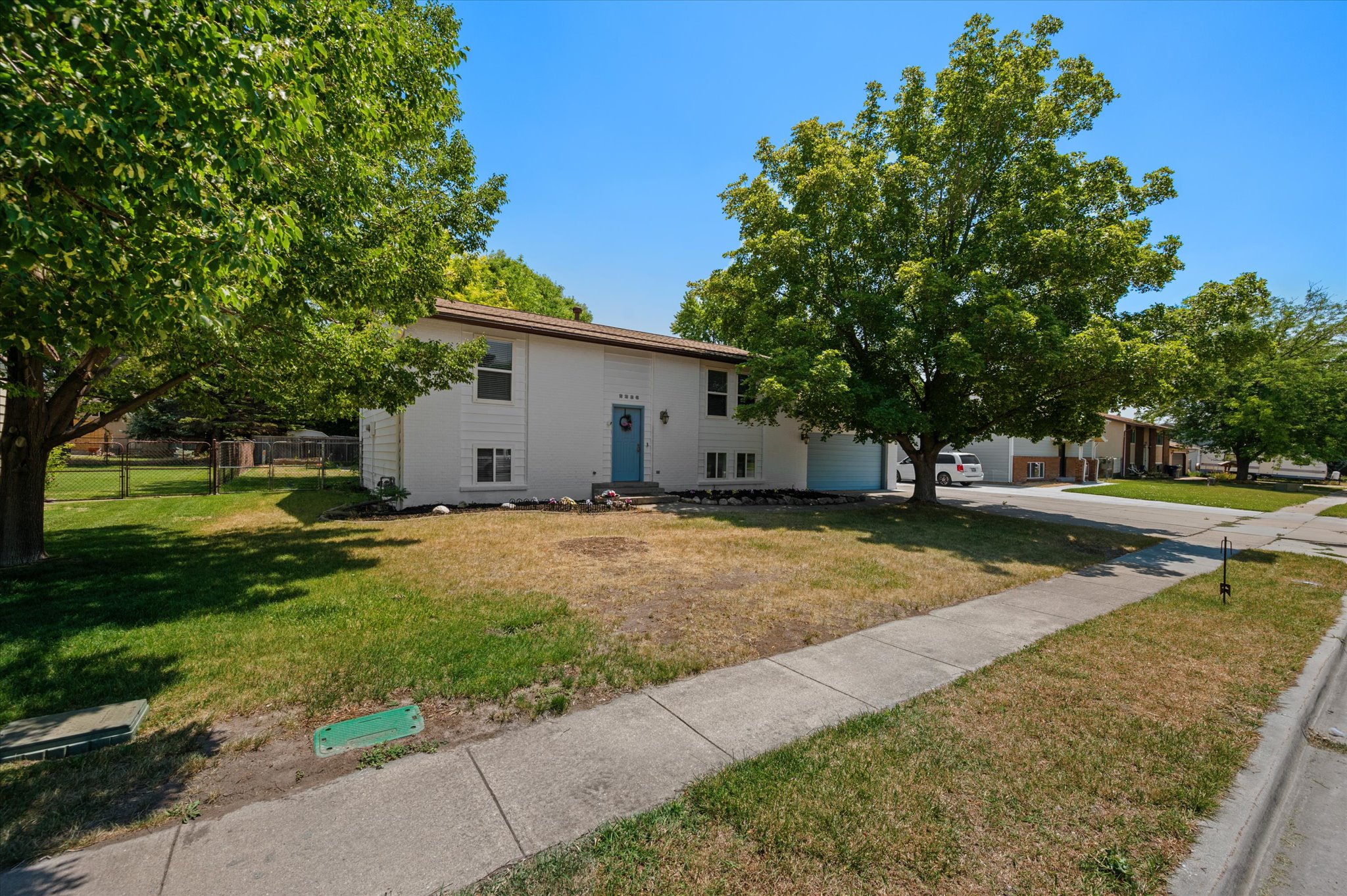 Two-story property featuring a white exterior with an accent blue front door