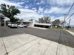 Paved parking area serving a multi-unit property with a covered carport