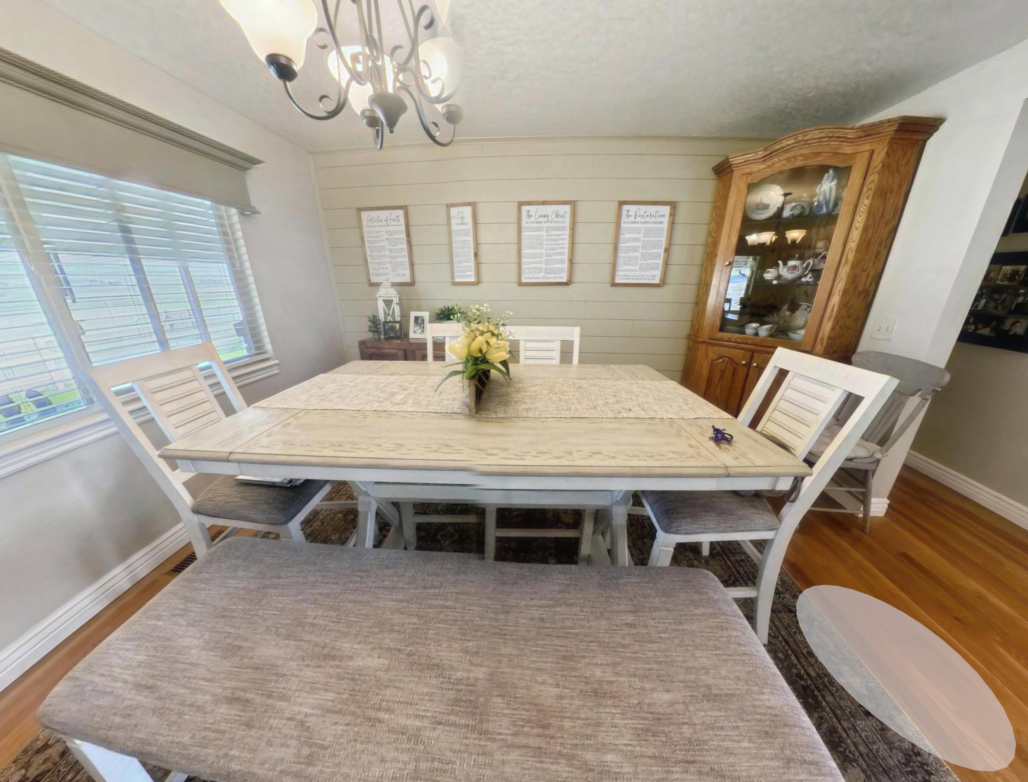 Dining space featuring a decorative chandelier, shiplap accent wall, and wood-finish flooring
