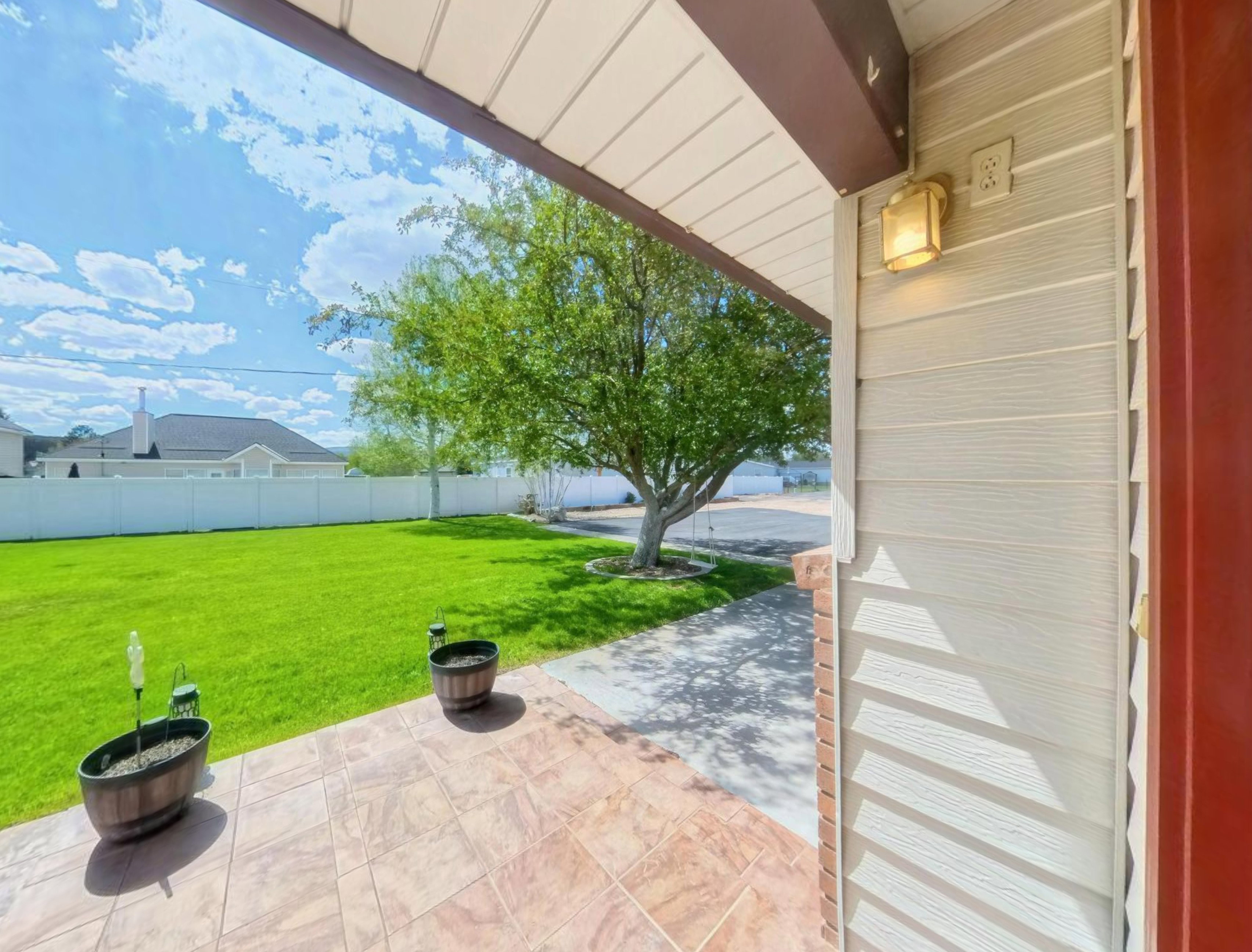 Covered porch featuring a tiled surface and an exterior light fixture