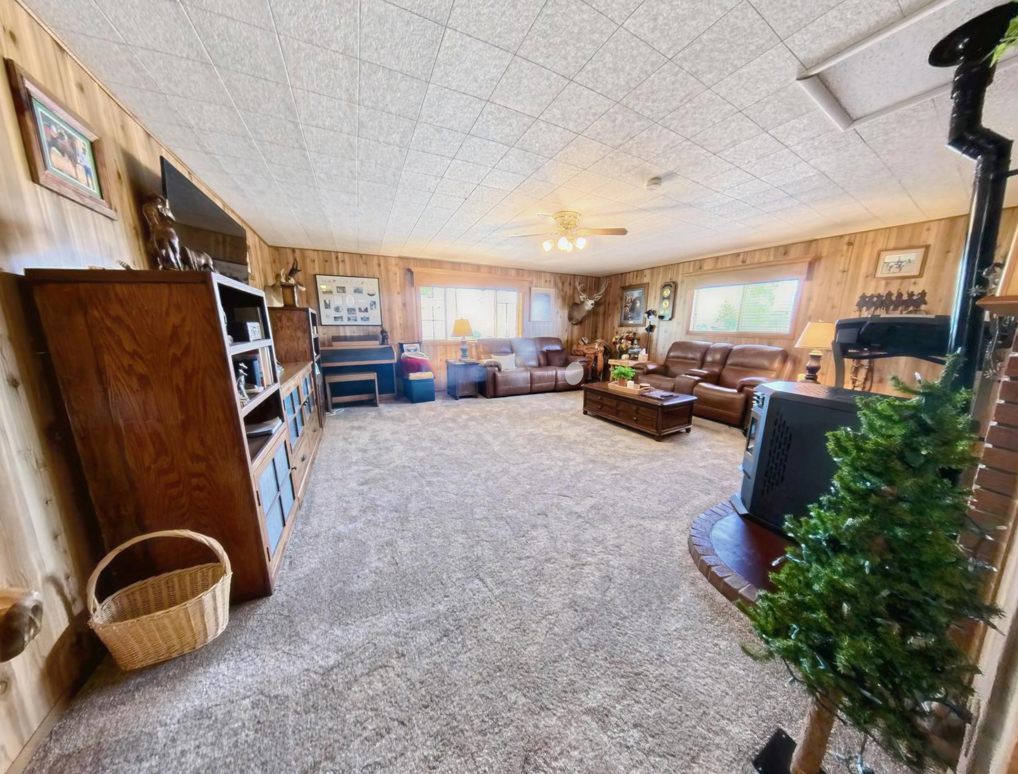 Spacious living area featuring wall-to-wall carpeting and extensive wood paneling