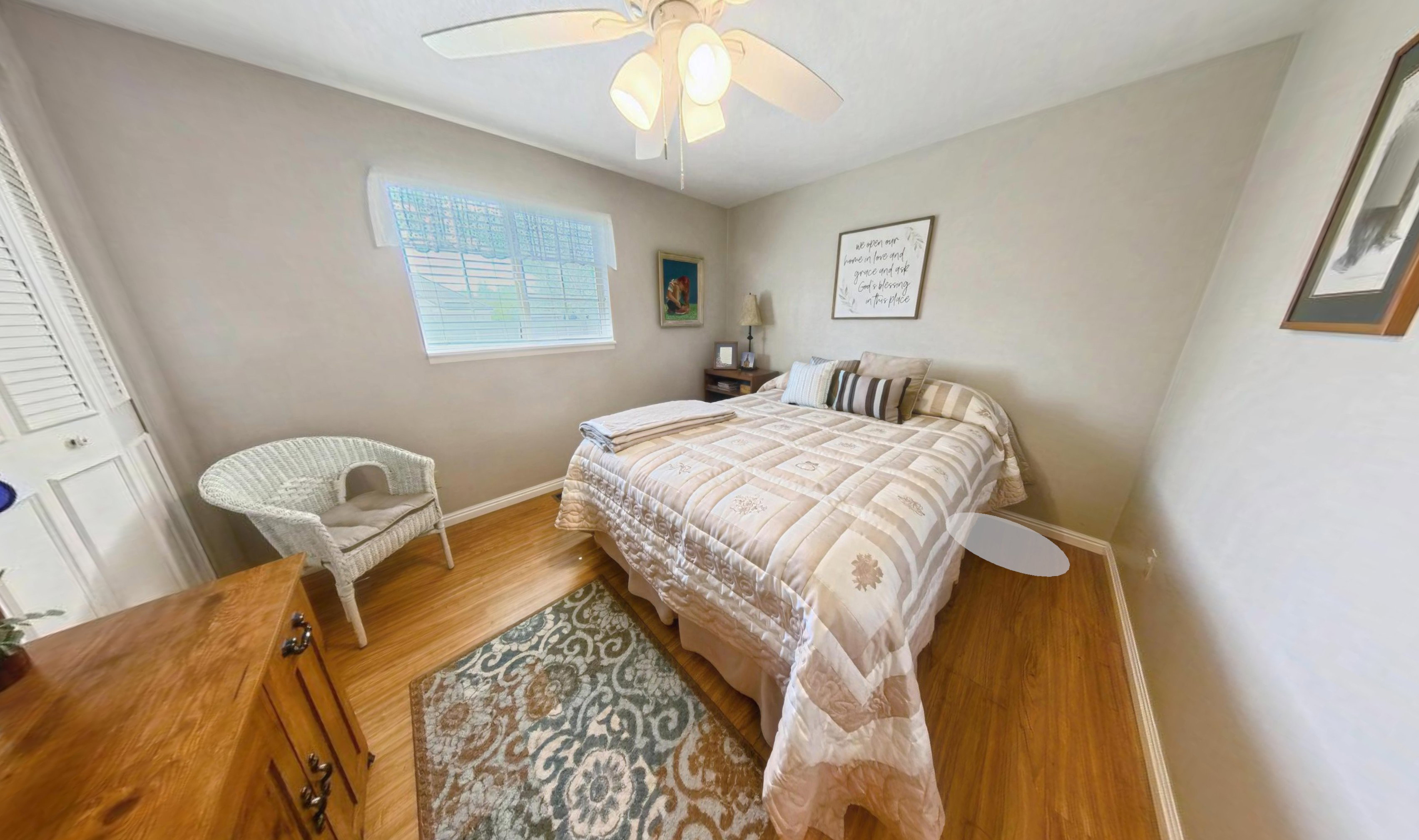 Bedroom featuring wood-finish flooring, neutral wall tones, and a ceiling fan with integrated lighting