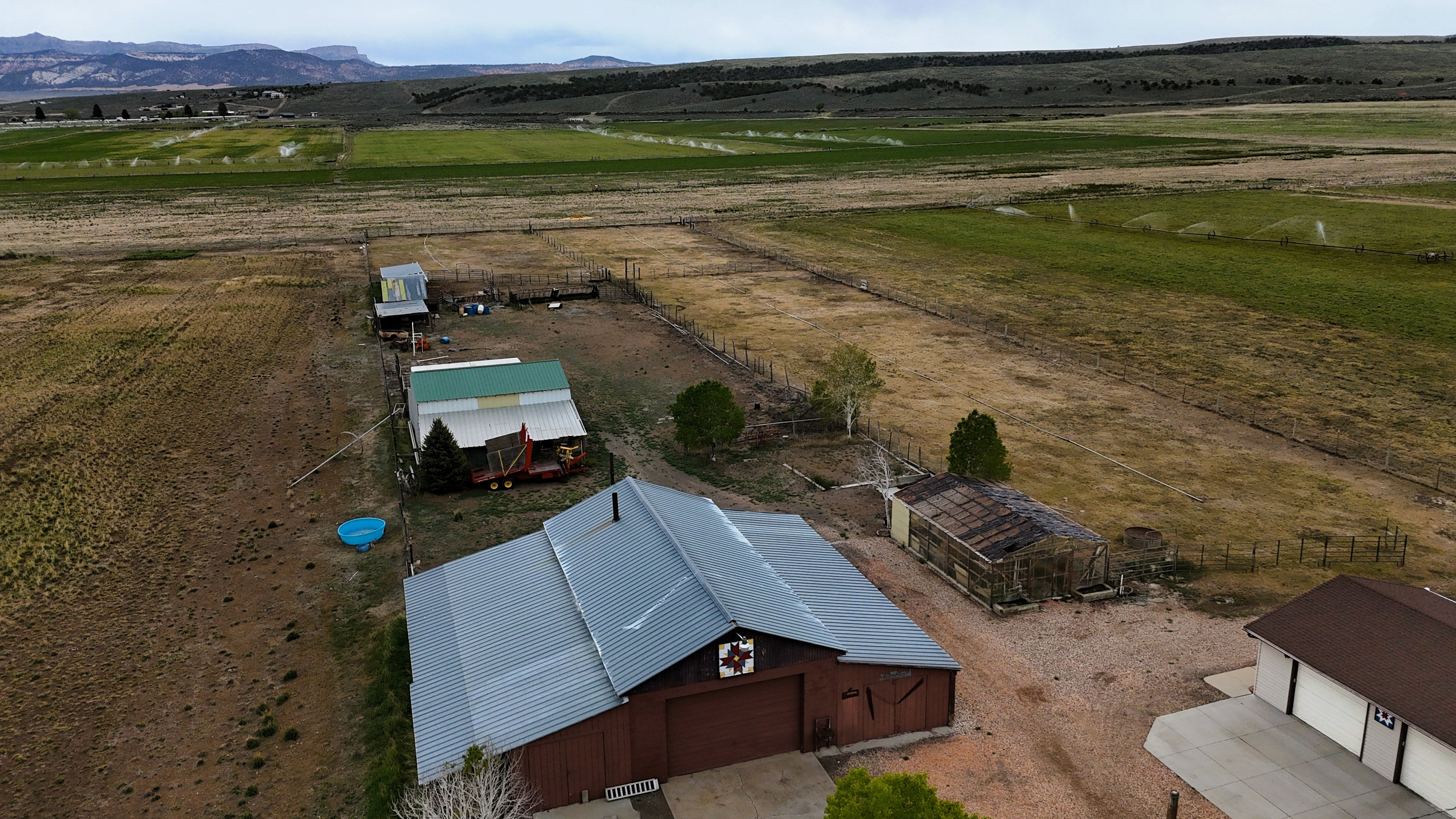 Aerial perspective showcasing multiple structures including a large barn with a metal roof and painted red siding