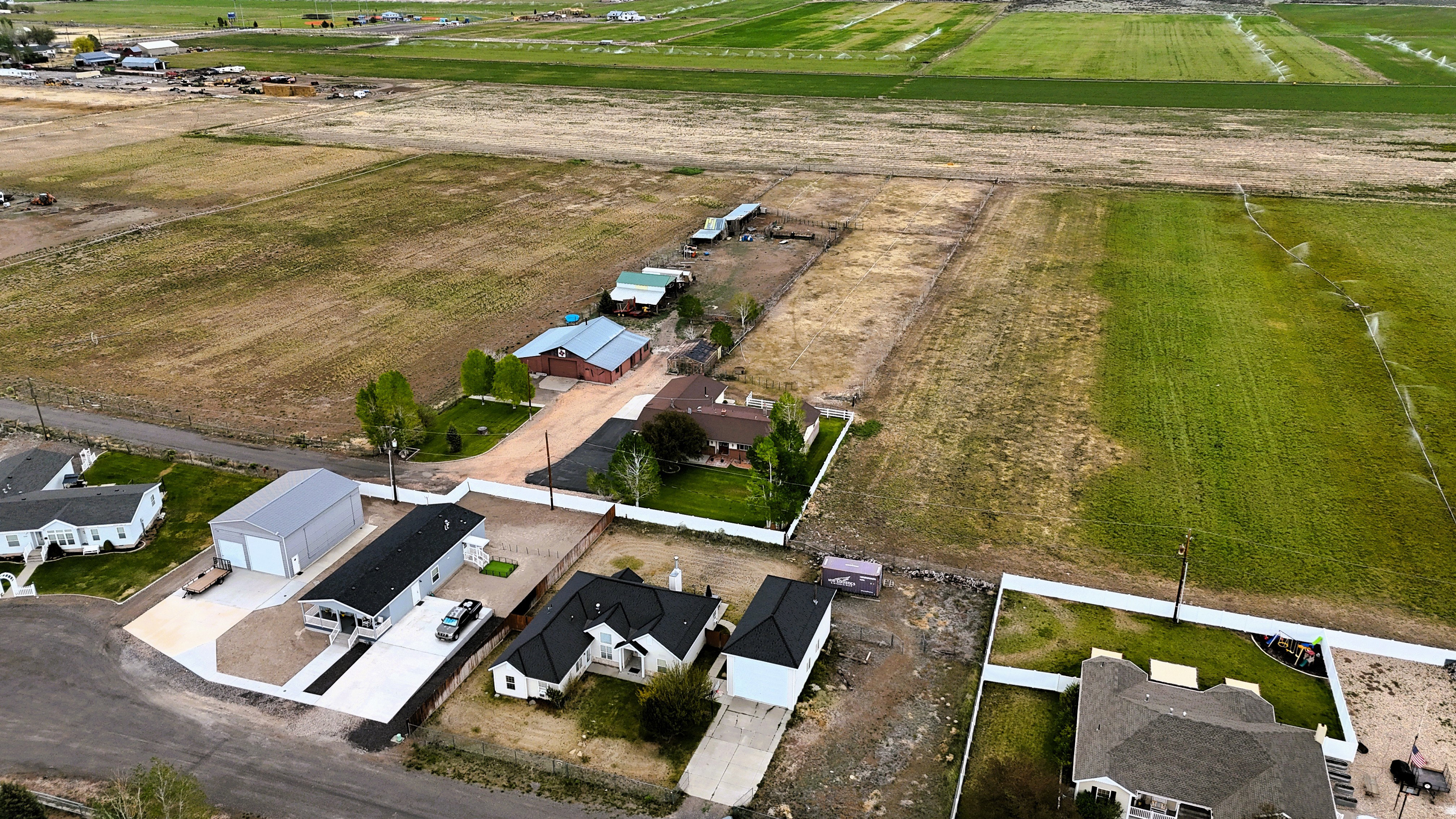 Aerial perspective showcasing multiple homes alongside expansive agricultural fields