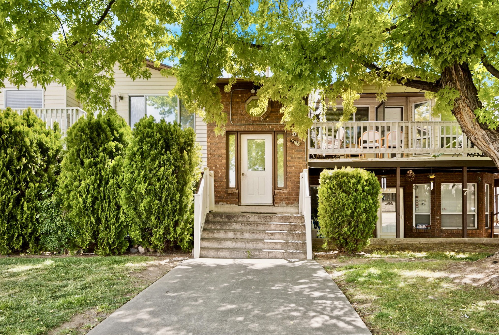 Brick and siding exterior with a concrete walkway leading to the main entrance