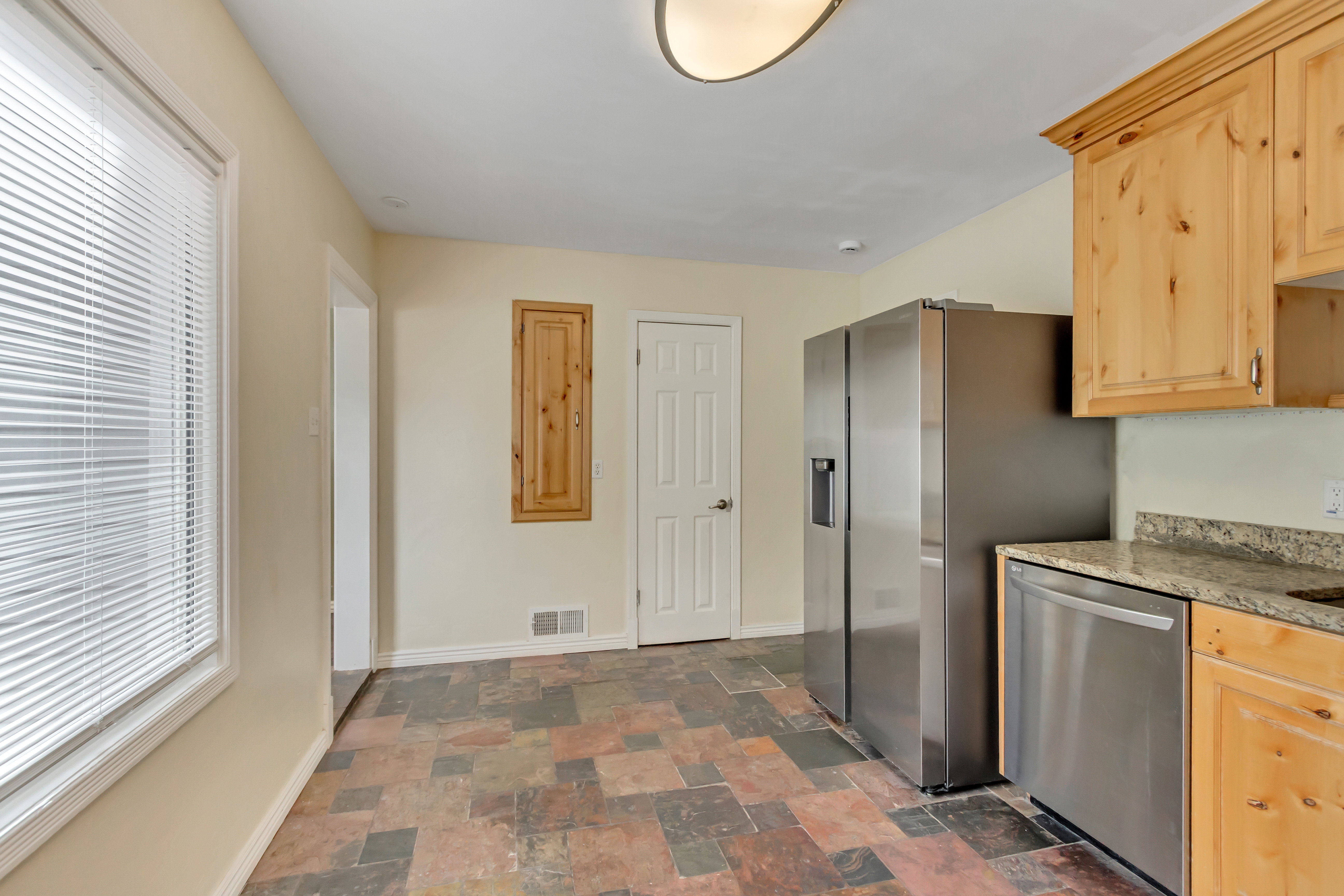 Kitchen space featuring natural wood-finish cabinetry, stone countertops, and stainless steel appliances