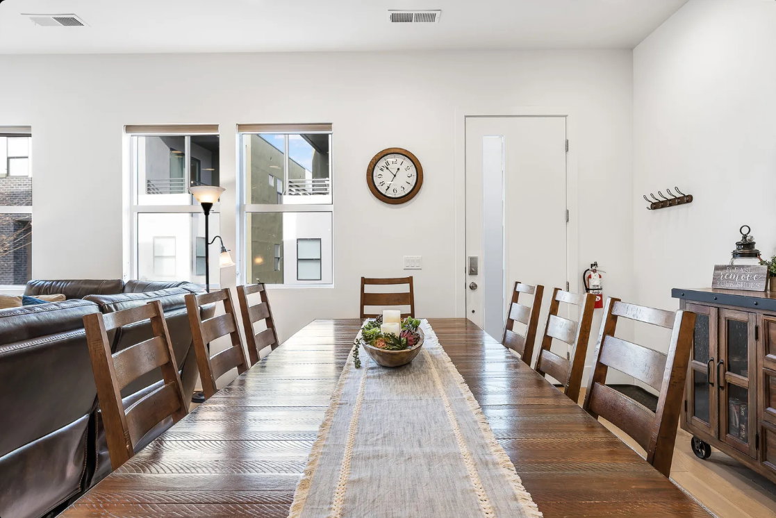 Expansive dining area featuring a long wood-finish table and seating for eight
