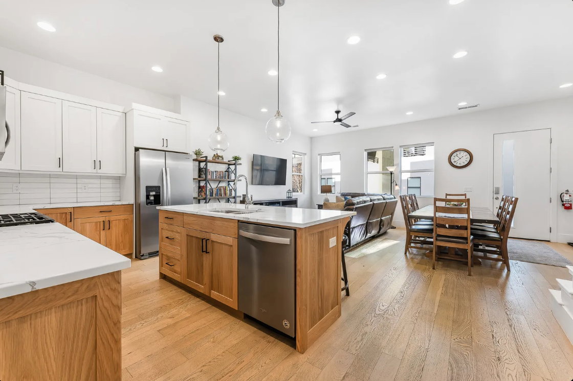 Open-concept living space featuring light wood-finish flooring, white walls, recessed lighting, and a contemporary ceiling fan