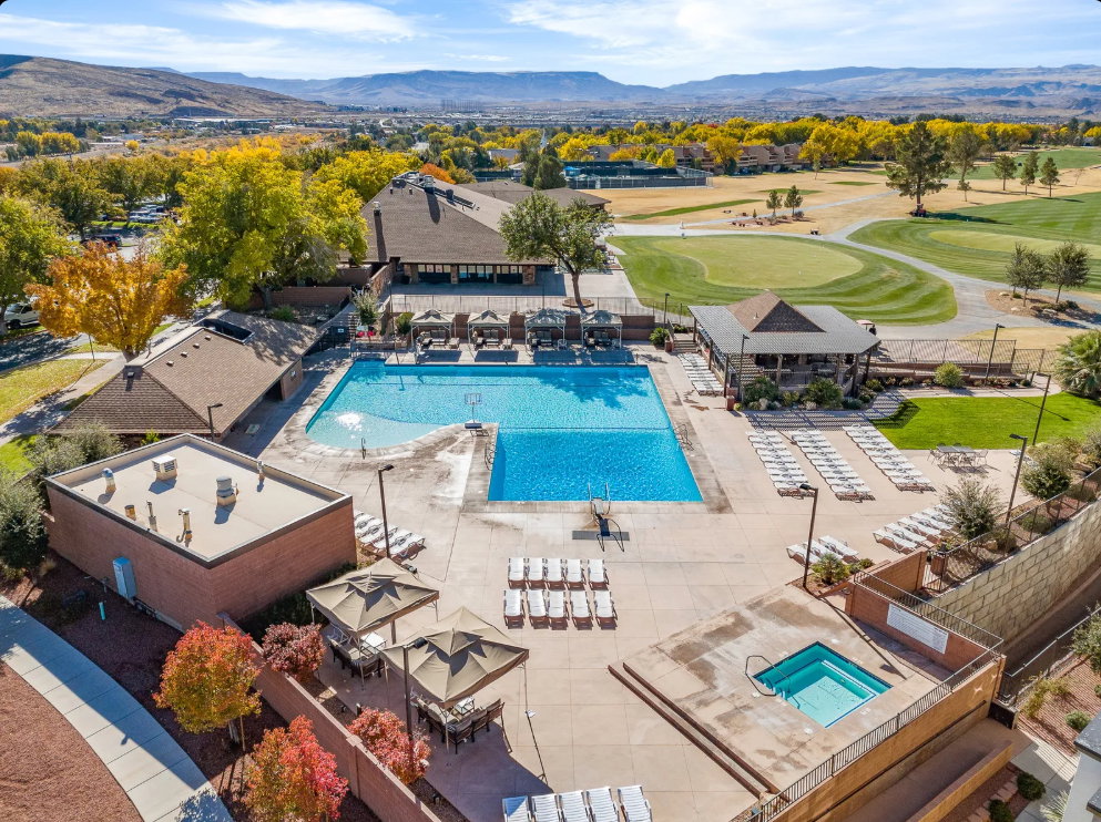 Expansive aquatic area featuring a large swimming pool, a separate hot tub, and surrounding lounge seating