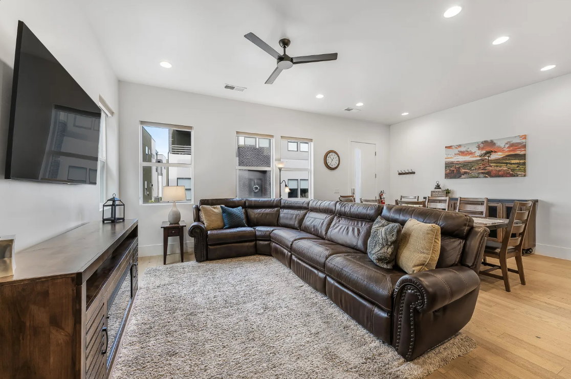 Open-concept living area with light wood-finish flooring and recessed lighting