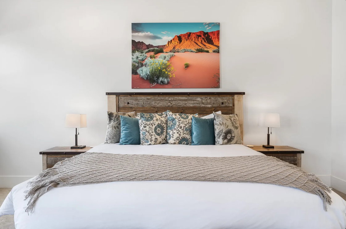 Bedroom featuring a wood-finish headboard, matching wood-finish side tables, and light-toned walls