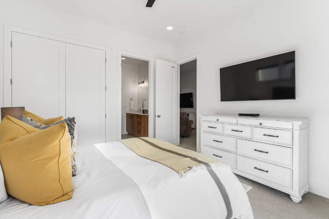 Bright bedroom featuring white walls, double closet doors, and recessed lighting
