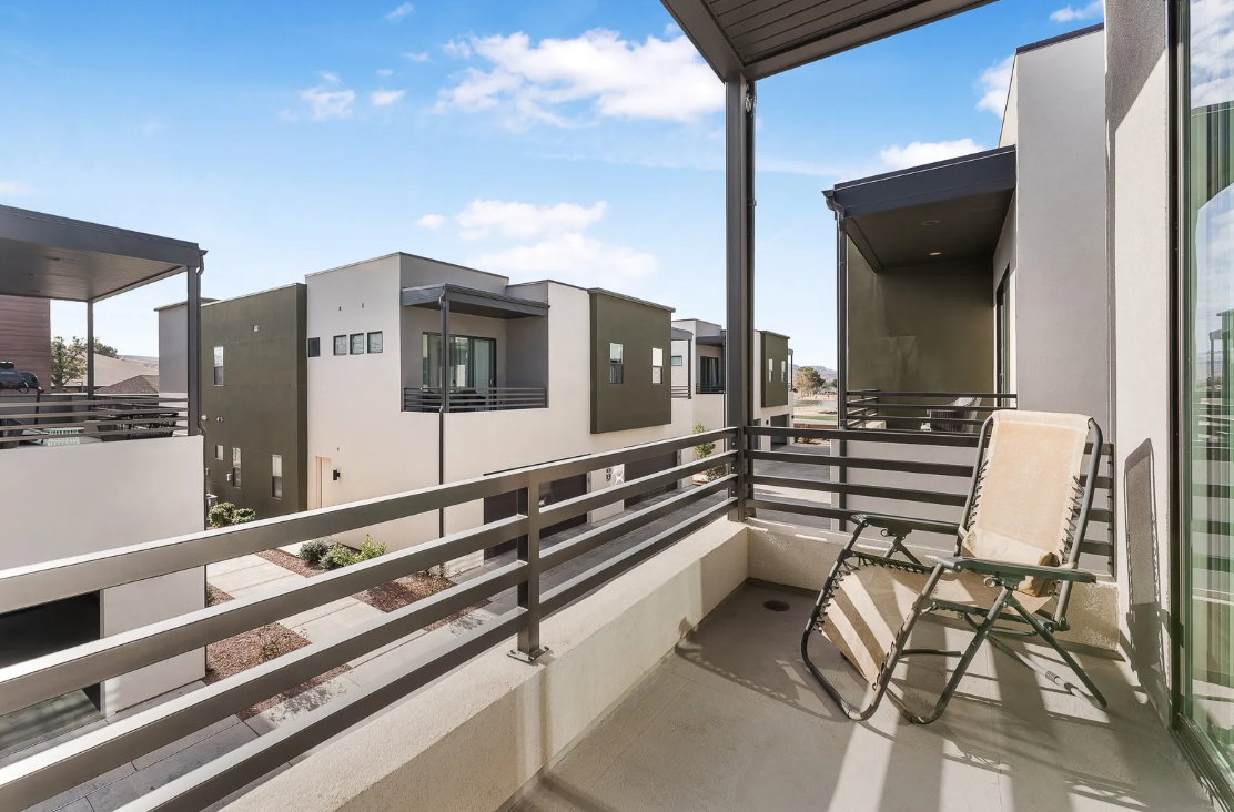 Private balcony featuring a concrete floor, metal railing, and an overhead structure