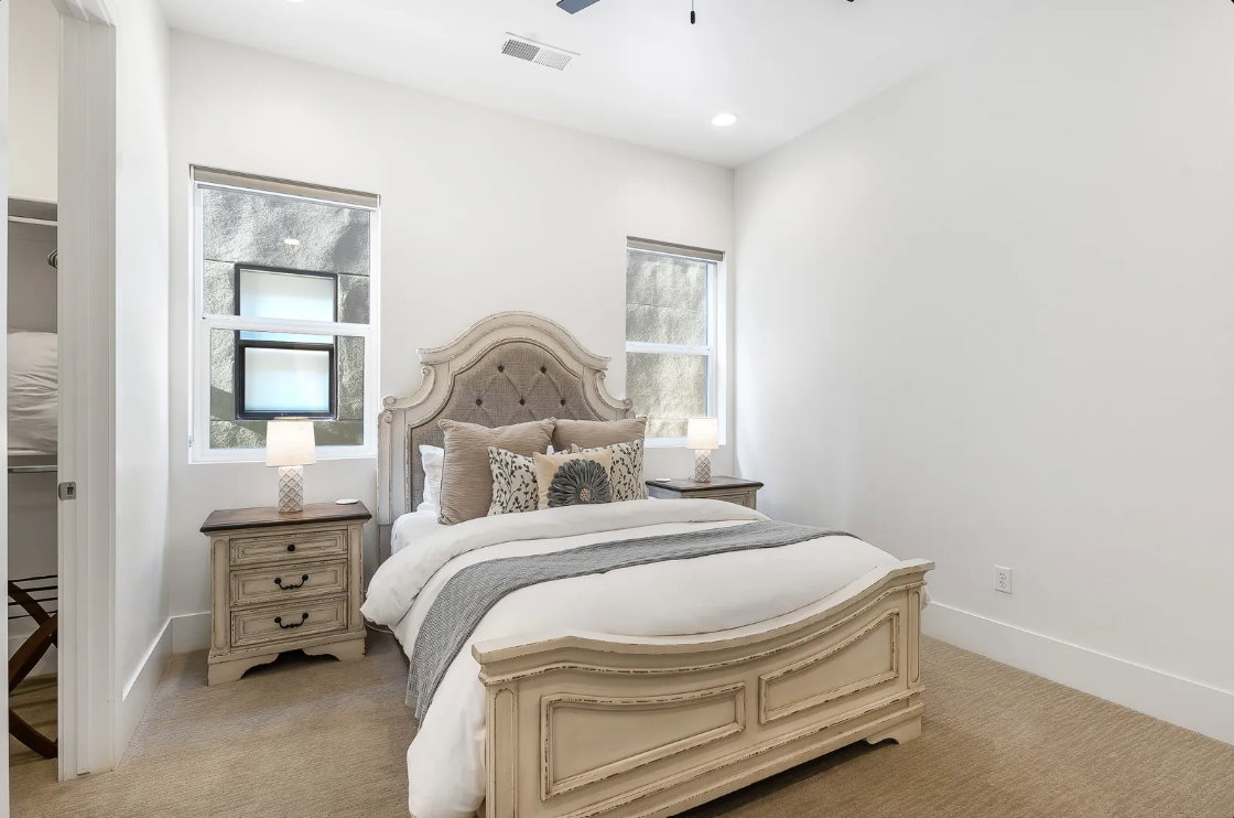 Carpeted bedroom featuring recessed lighting, a ceiling mounted light fixture, and two windows with window treatments
