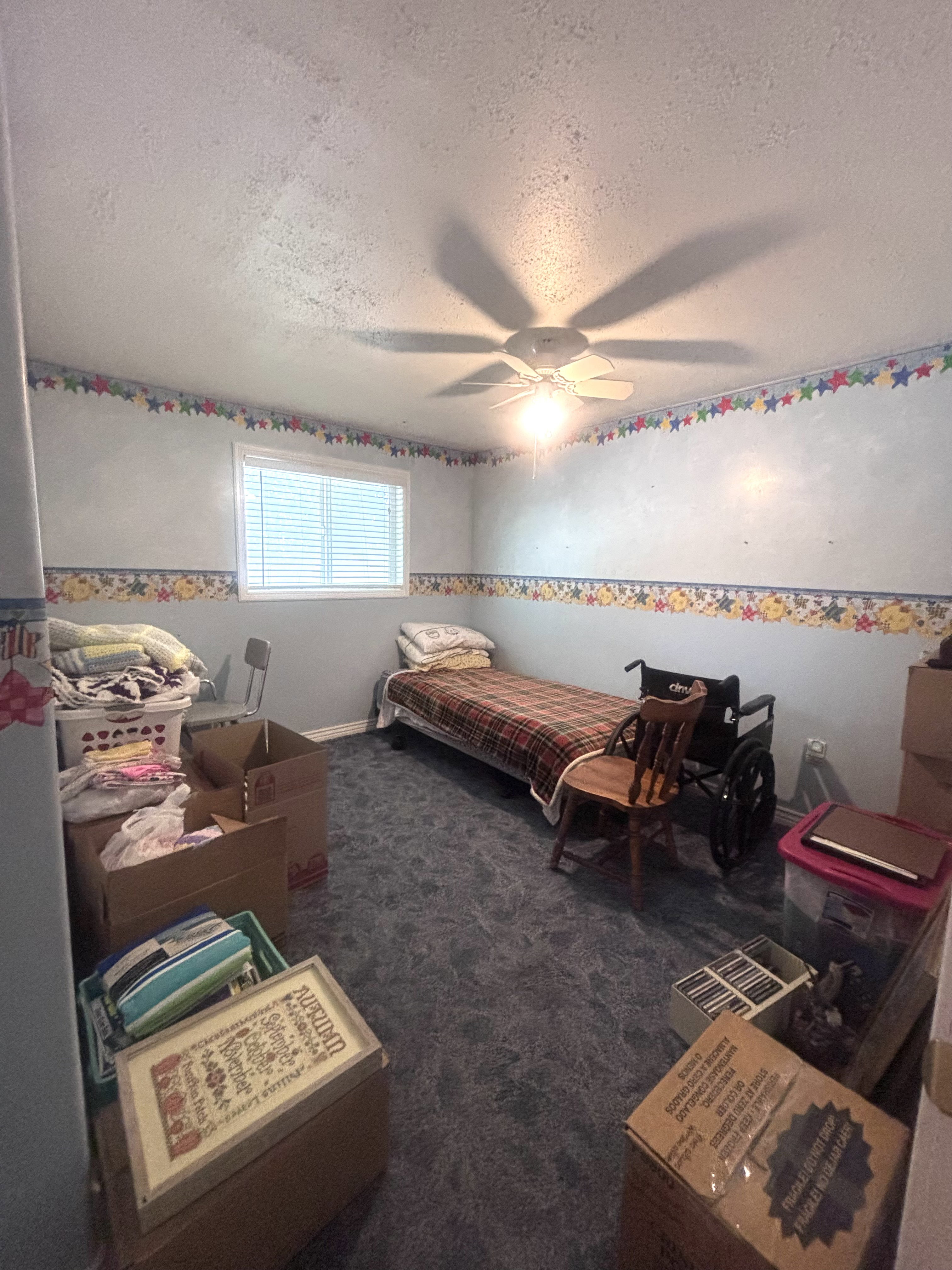 Room featuring a window with horizontal blinds, a ceiling fan with integrated lighting, and blue textured carpeting