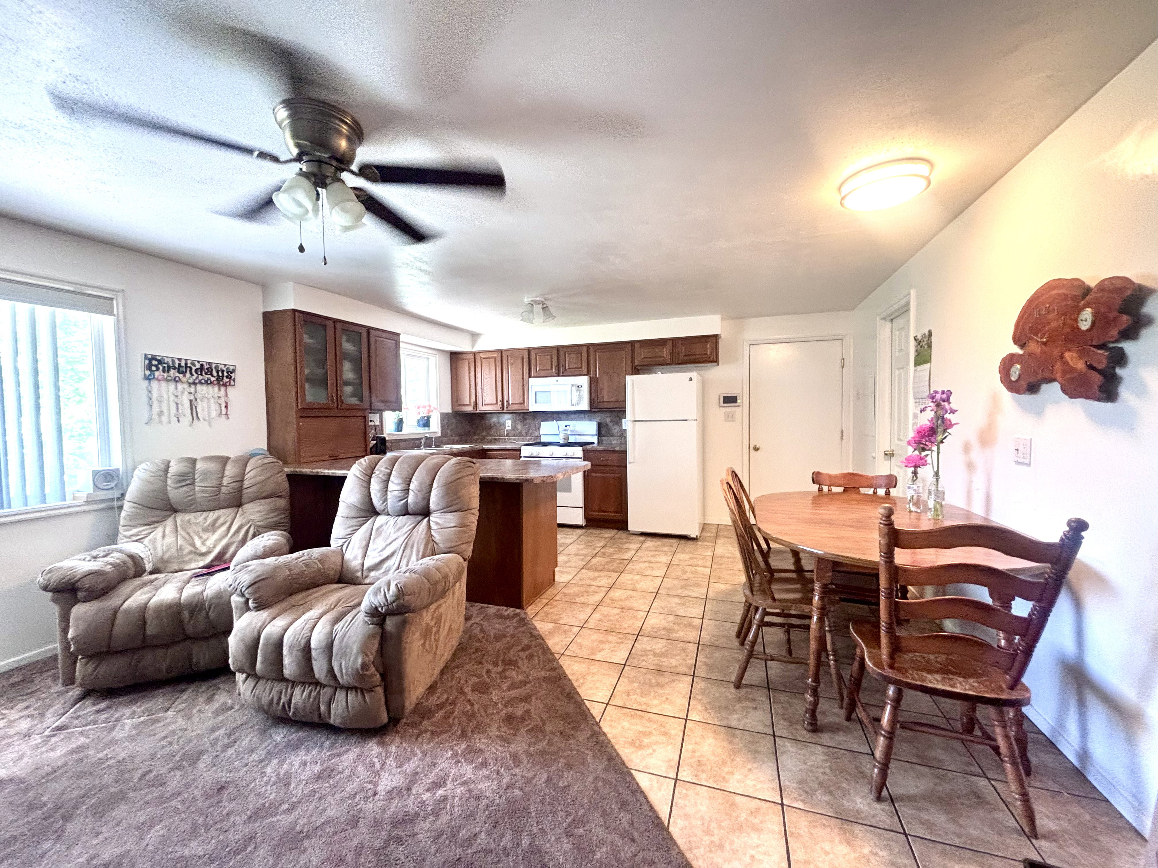 Open concept living area featuring a kitchen with wood cabinetry, a breakfast bar, and tile flooring