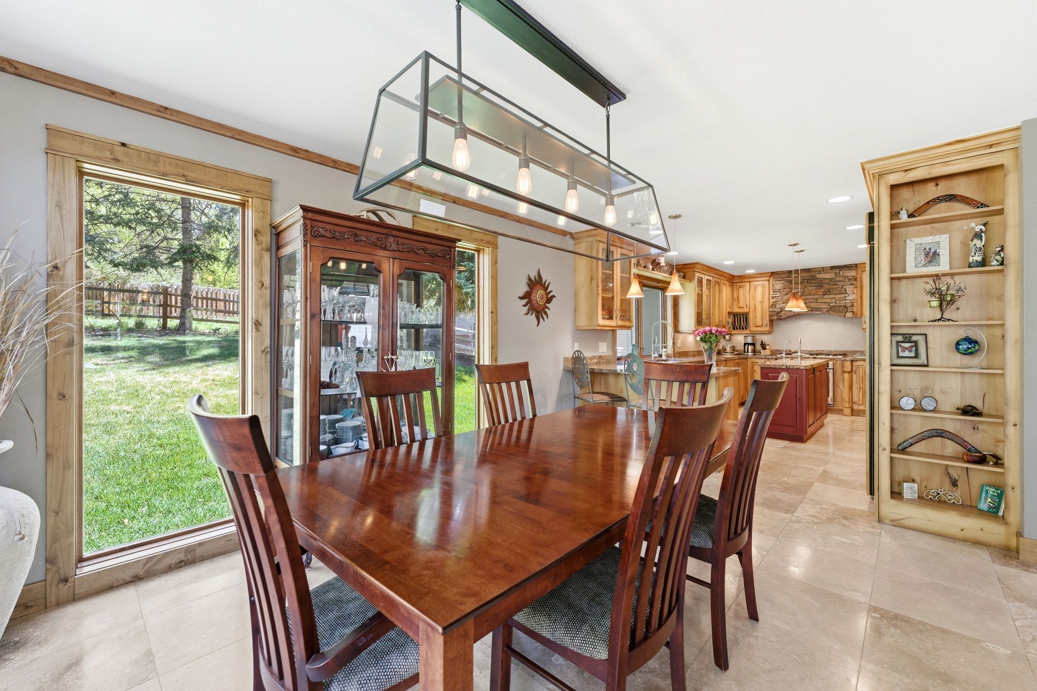 Dining area featuring a modern linear chandelier, wood-finish flooring, and a built-in display cabinet