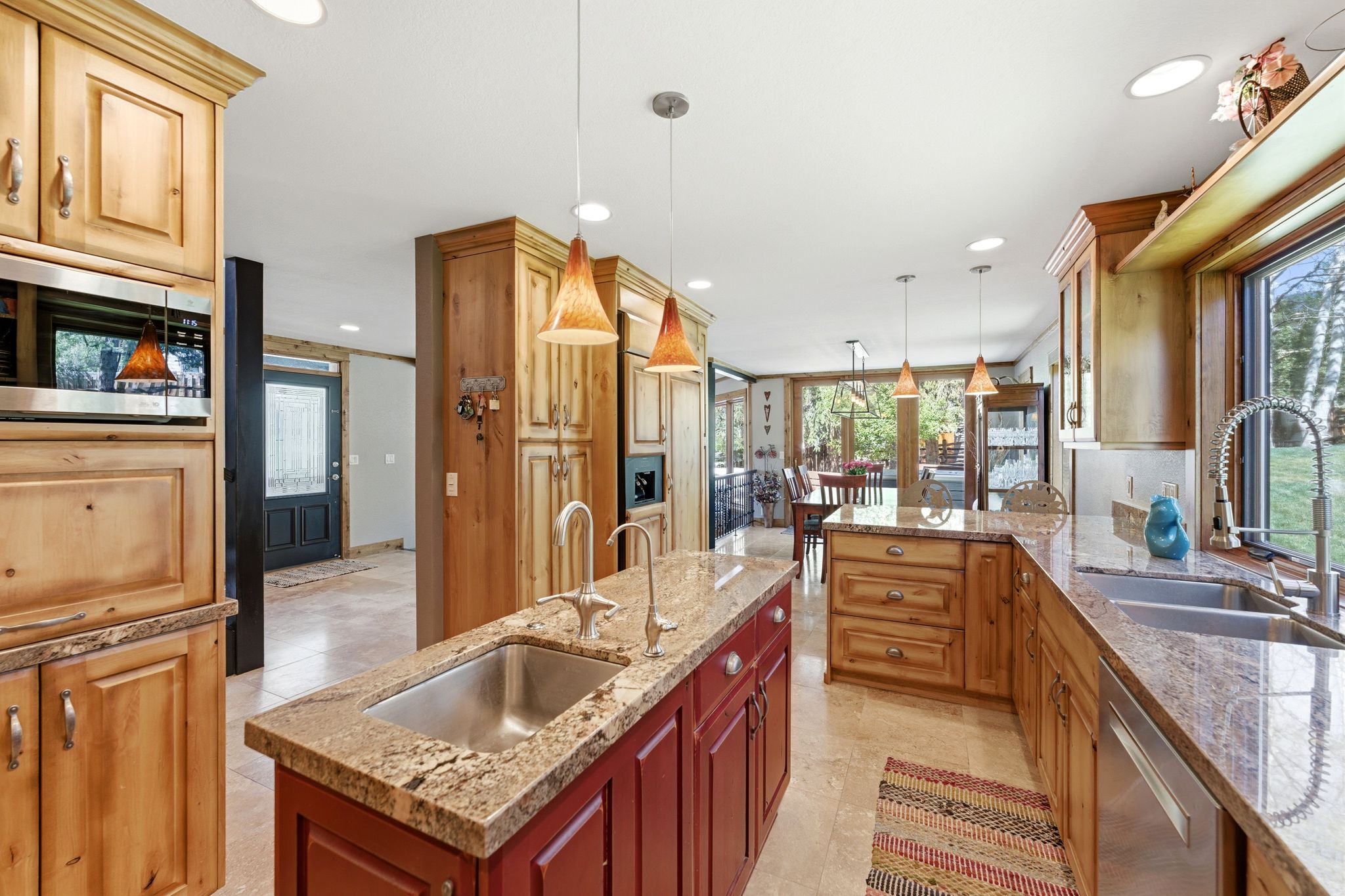 Kitchen featuring a central island with an undermount sink, granite countertops, wood cabinetry, and recessed lighting