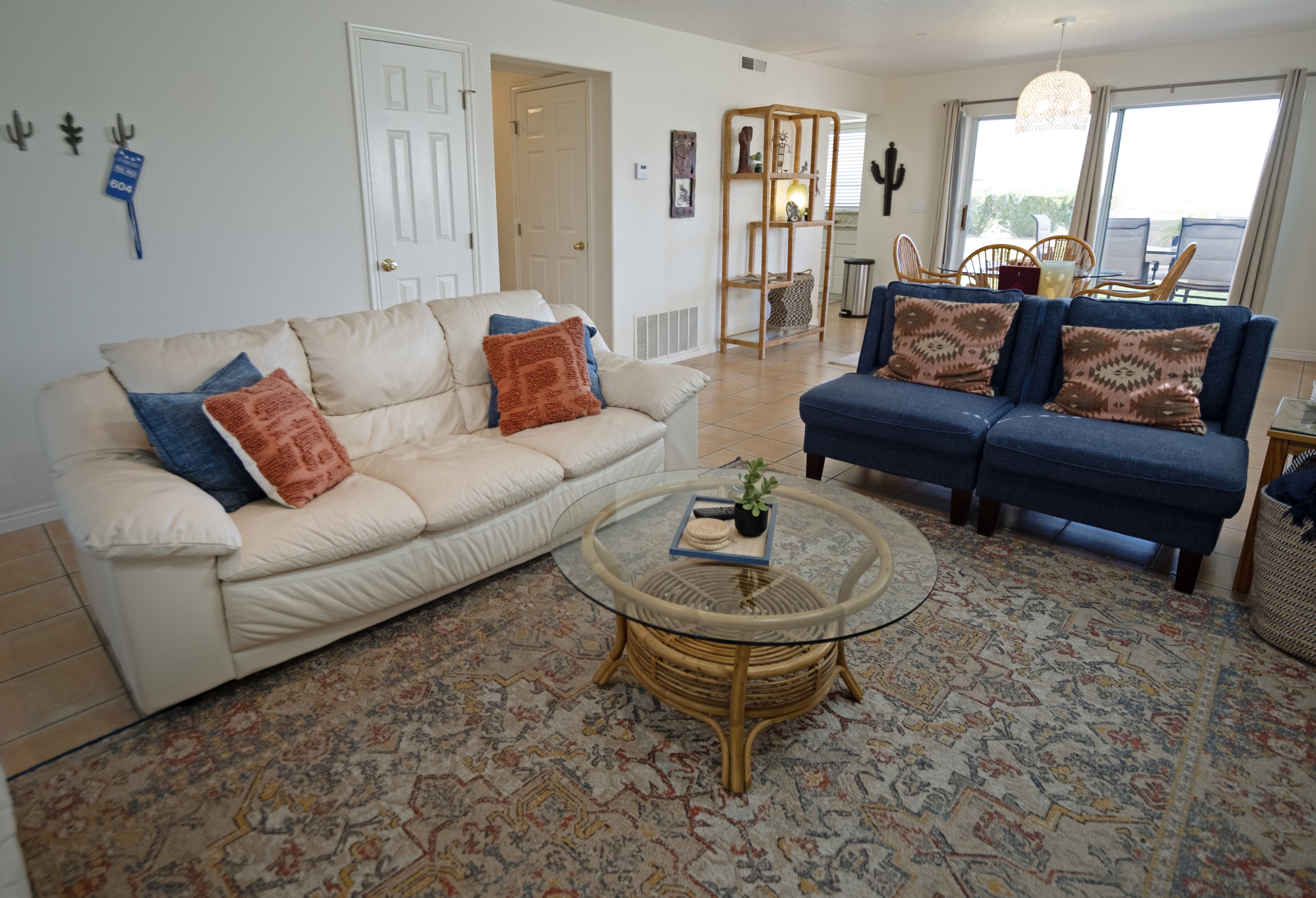 Open concept living area featuring light-toned walls, tile flooring, and direct access to an outdoor patio via sliding glass doors