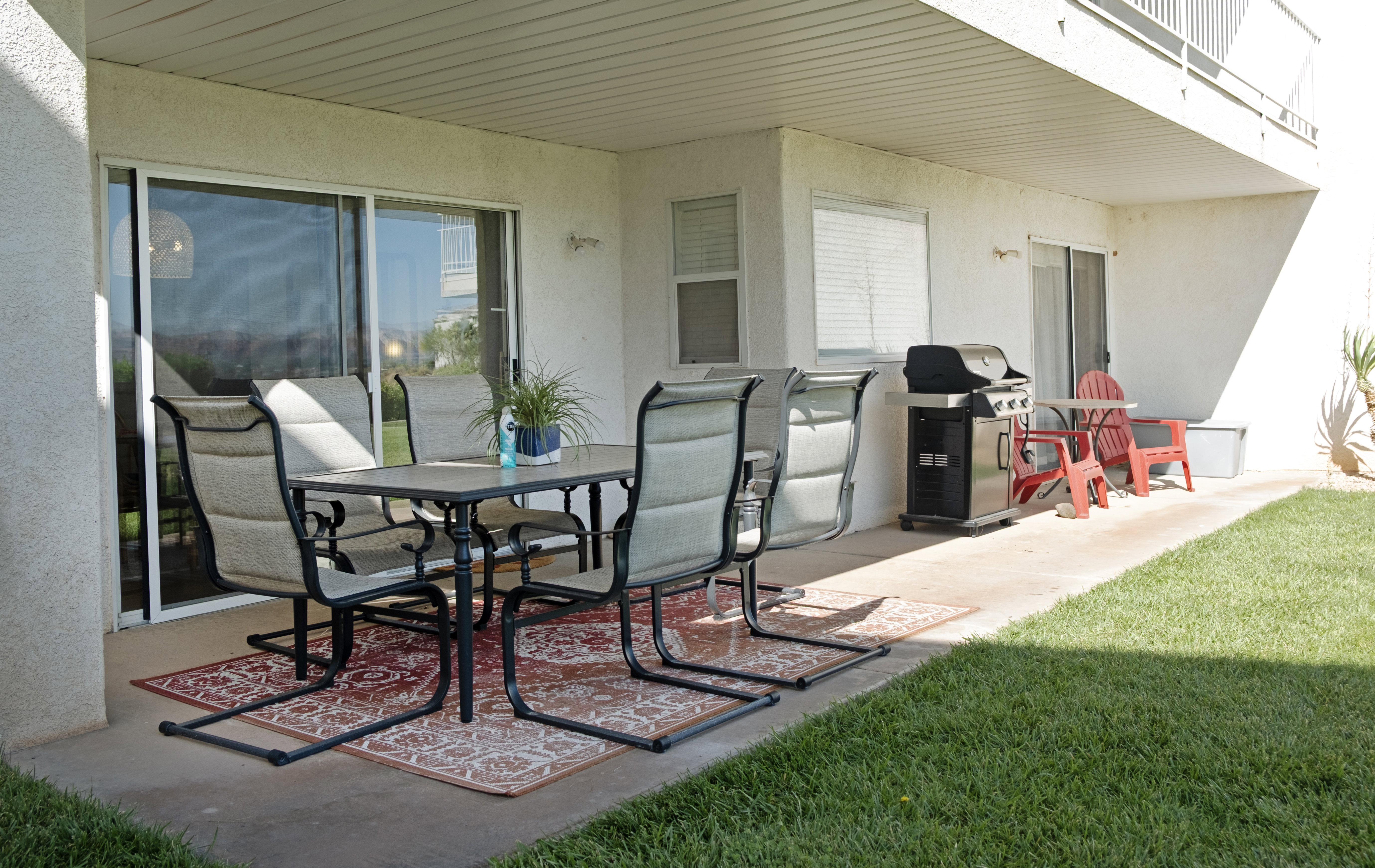 Ground-level patio featuring a concrete slab, sliding glass door entry, and an overhead soffit