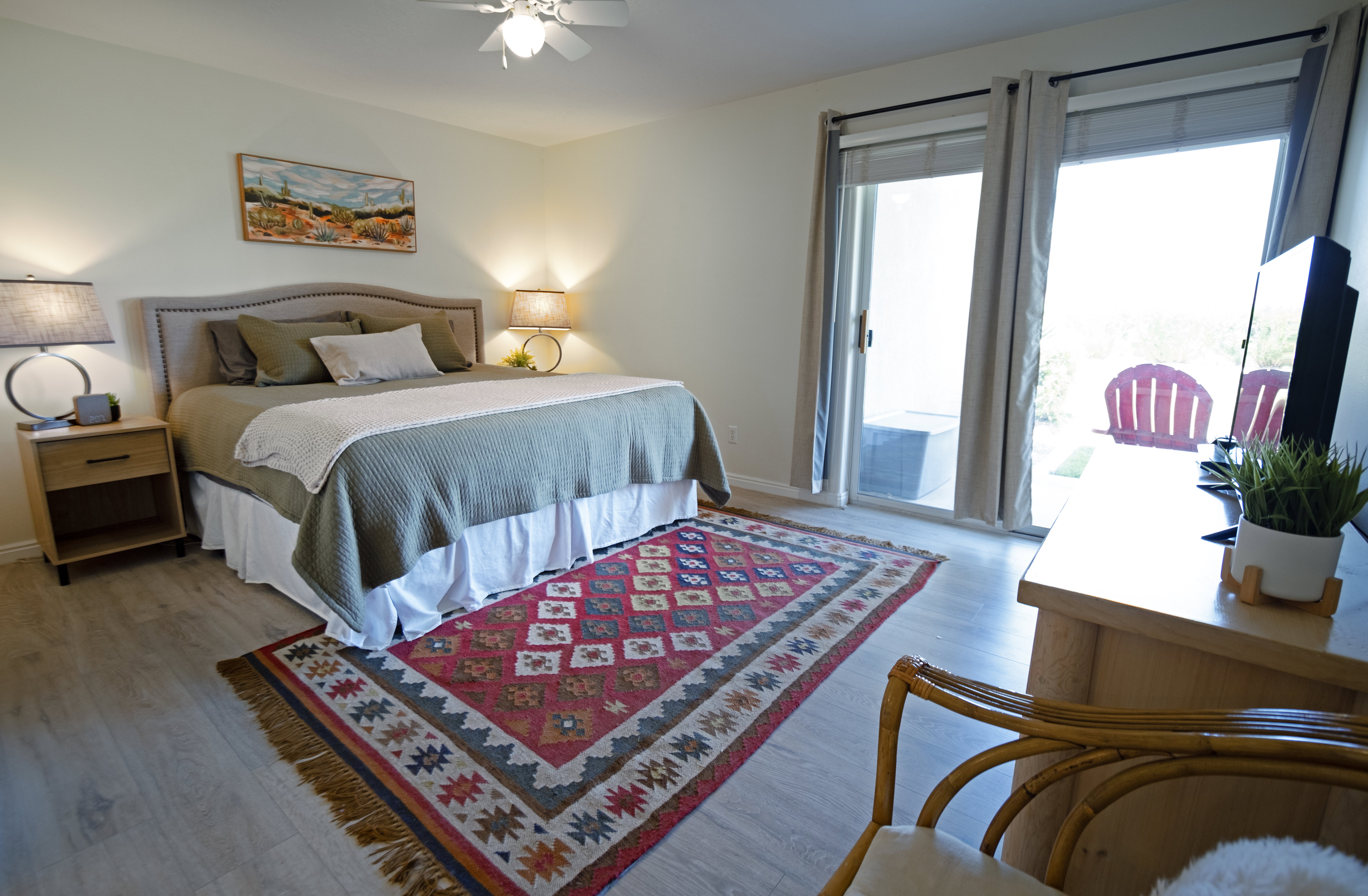 Spacious primary bedroom featuring wood-finish flooring, a ceiling fan, and direct access to the patio through a sliding glass door