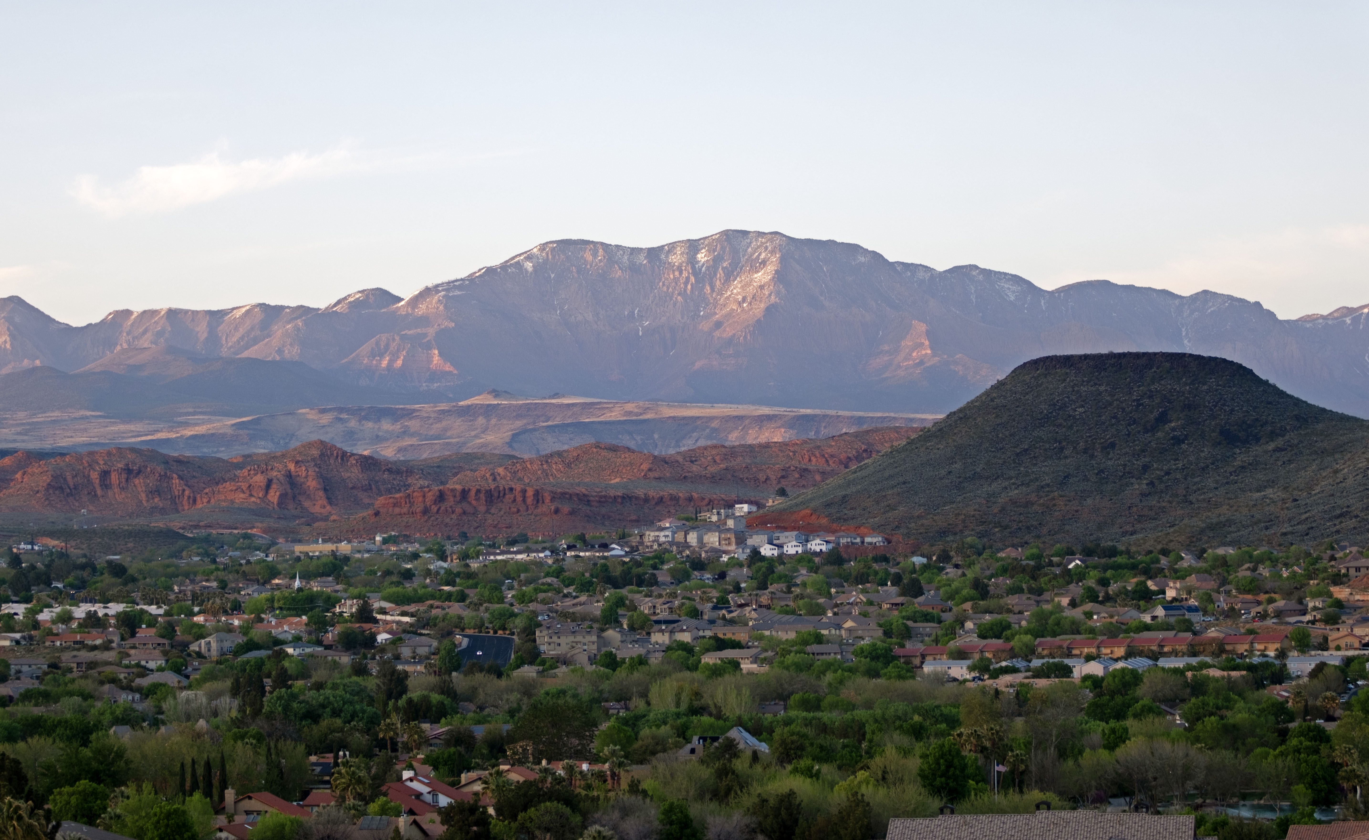 Expansive mountainous terrain with snow-capped peaks and red rock formations