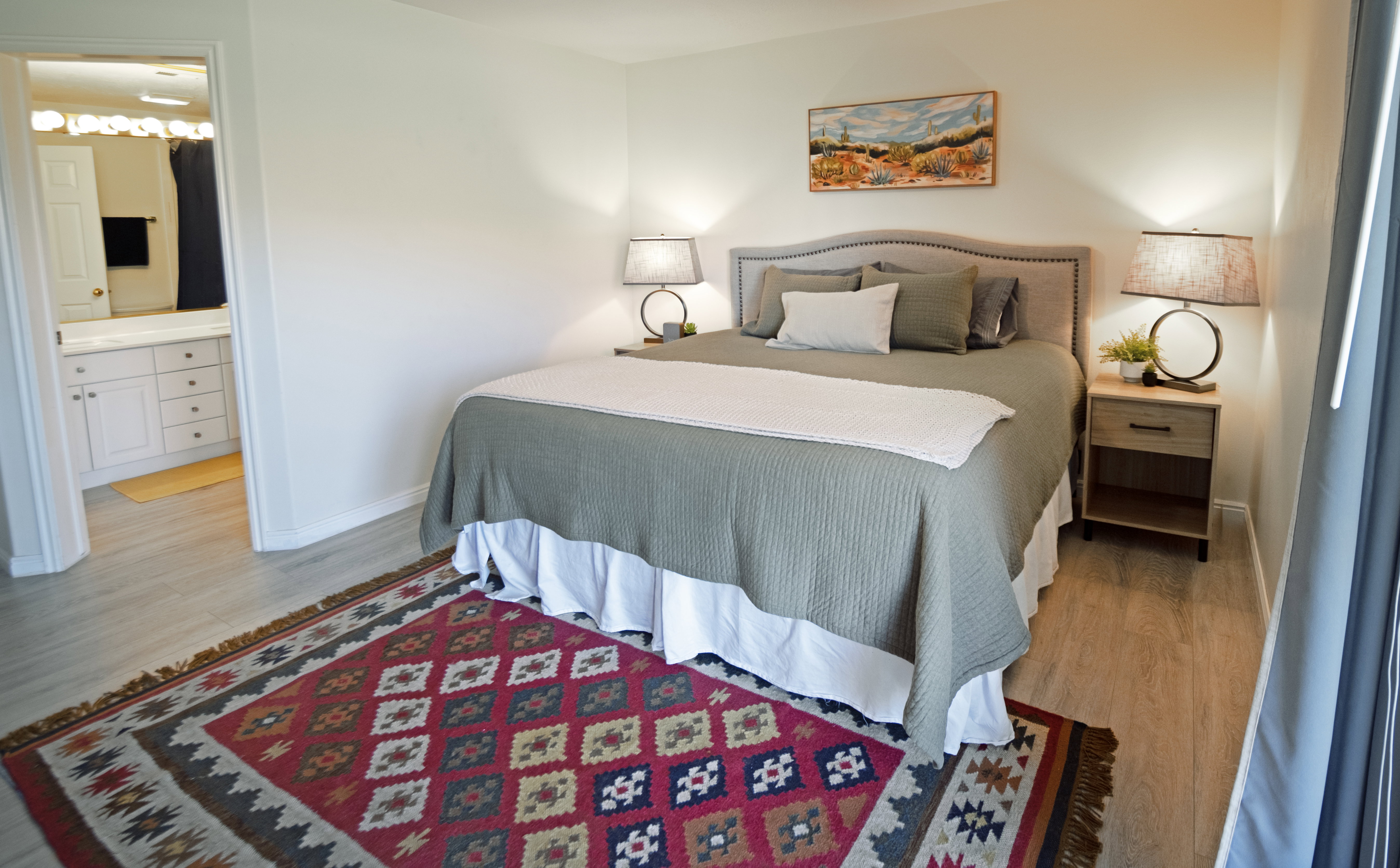 Primary bedroom, wood-finish flooring with an adjacent bathroom entry